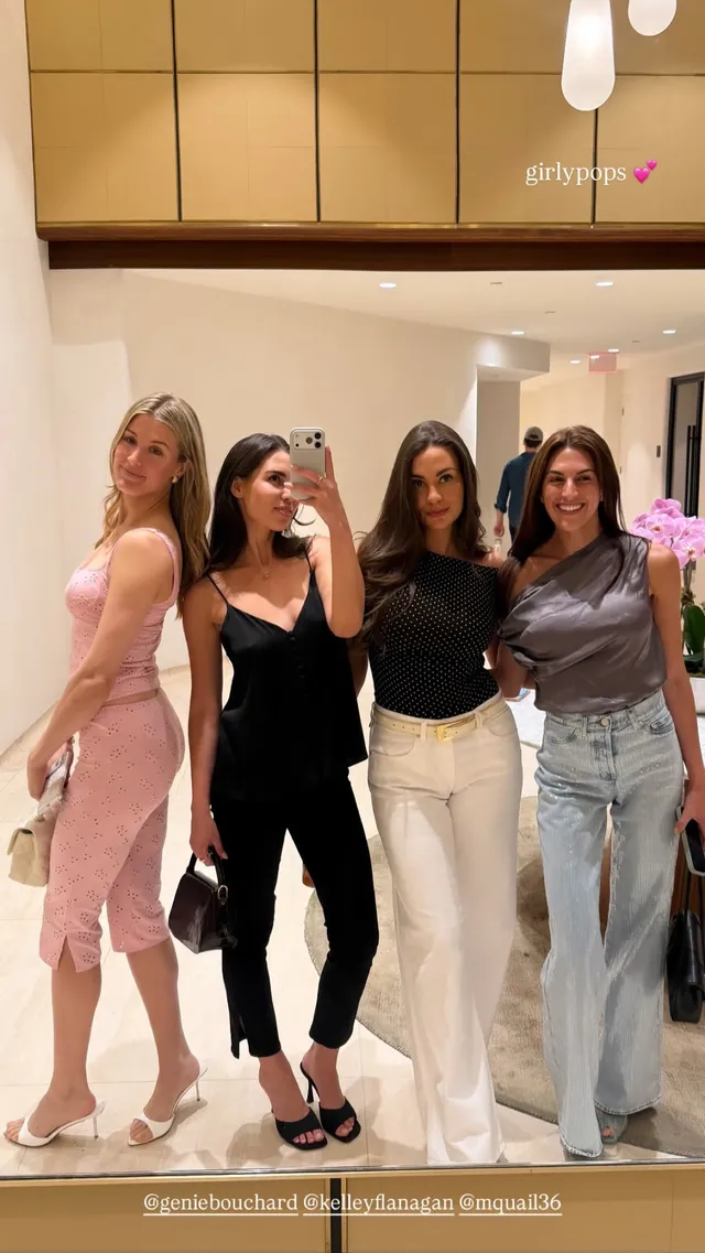 Eugenie Bouchard posing with companions in pale heels and a pink dress.