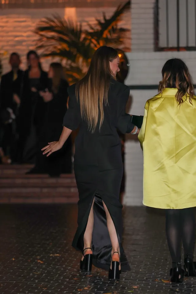Olivia Wilde walking in a black dress and high heels.