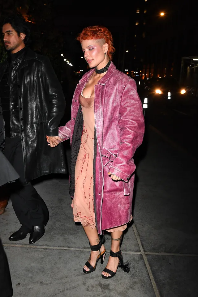 Halsey a pink coat and black heels at night.