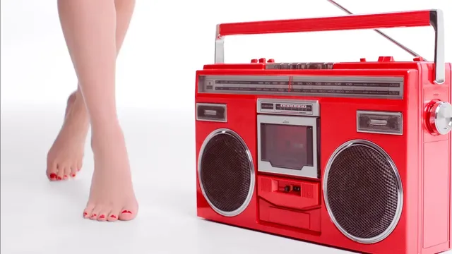 Natalie Portman showing bare feet beside a red radio in a studio photograph.
