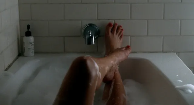 Kirsten Dunst resting bare feet near the end of a bathtub.