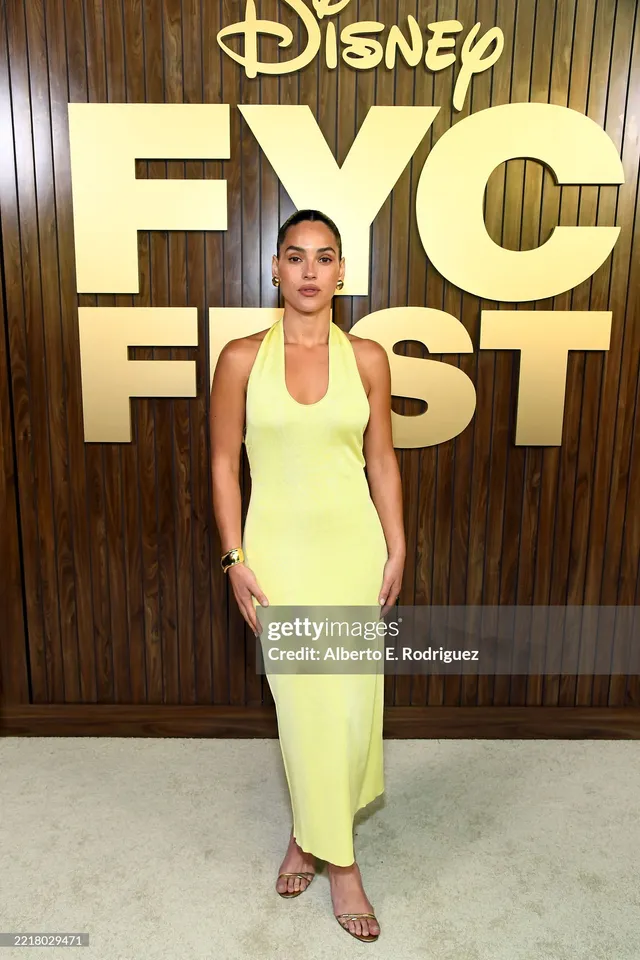 Adria Arjona wearing a pale yellow dress and open-toe heels at an event.