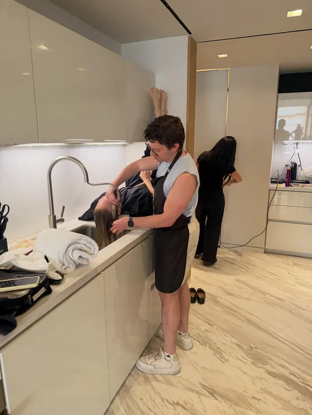 Brittany Snow standing beside a kitchen counter in a casual outfit.