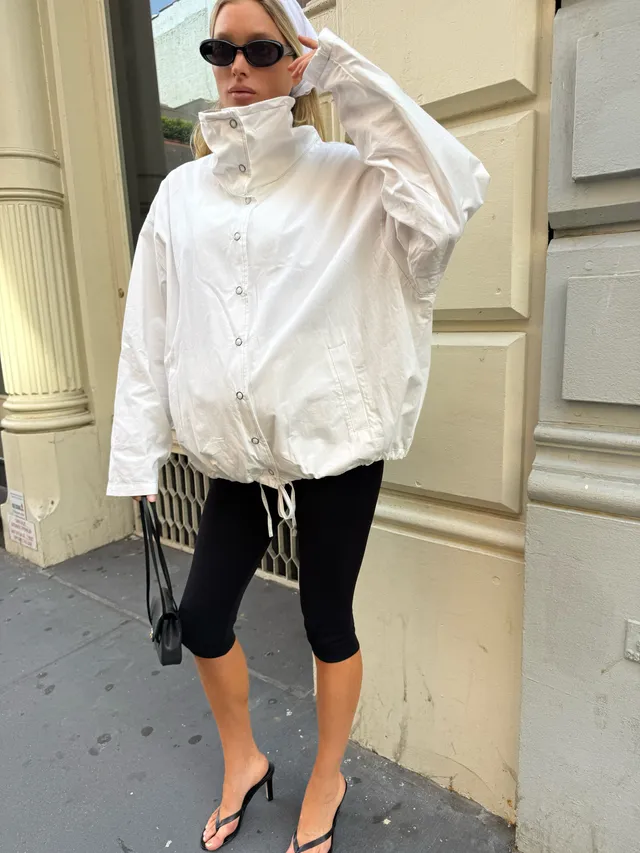 Elsa Hosk wearing black heeled sandals with a white jacket and black cropped leggings.