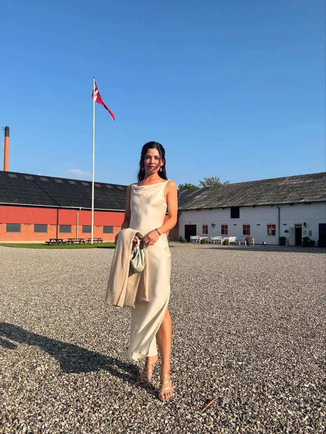 Danielle Campbell standing outdoors in a cream outfit.