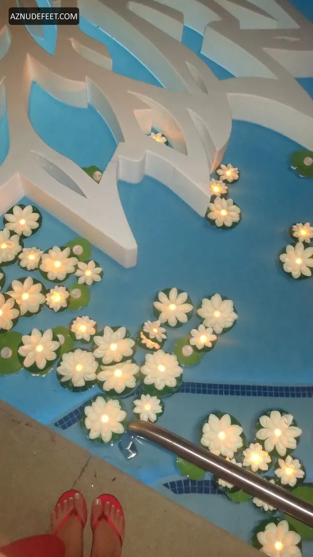 Cierra Ramirez wearing red flip-flops beside a pool decorated with floating flowers.