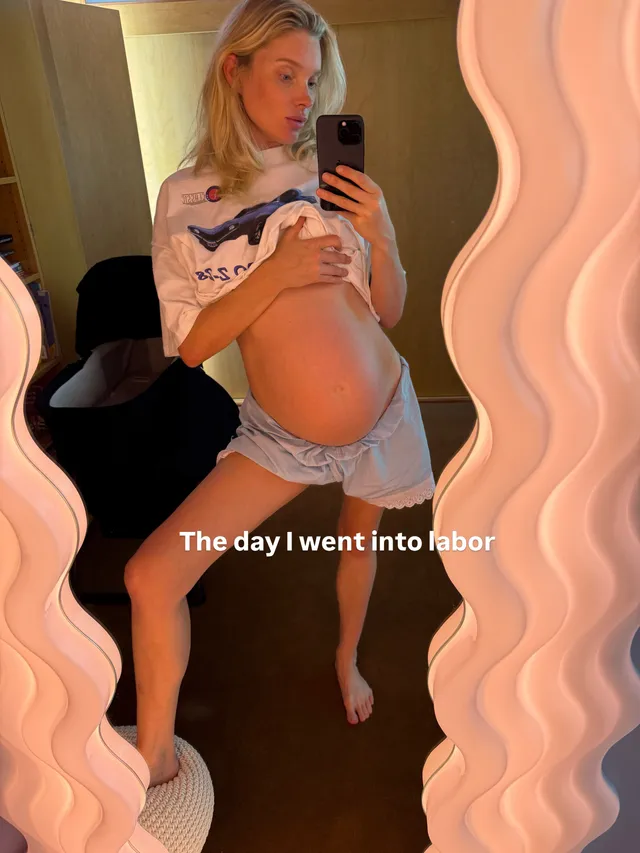 Elsa Hosk taking a barefoot mirror photograph in a T-shirt and shorts.