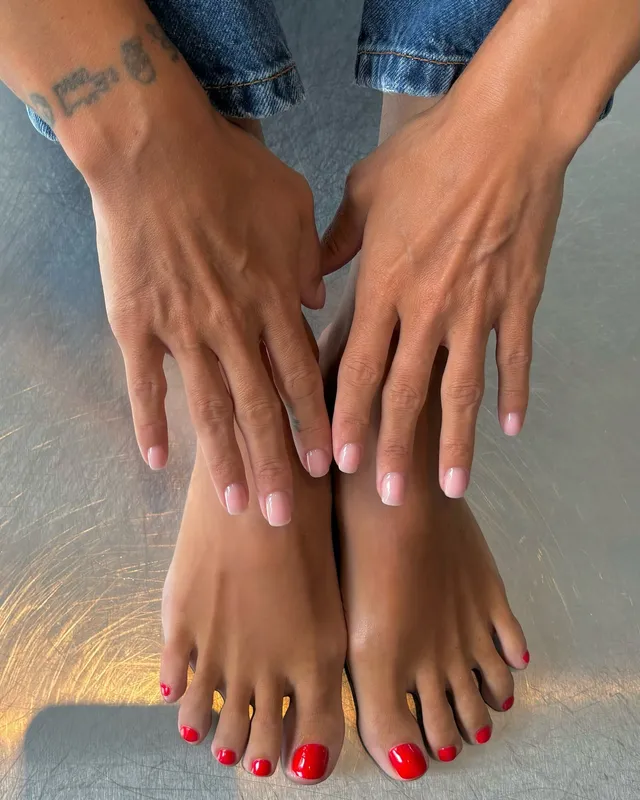 Lily Allen resting her hands beside her feet.