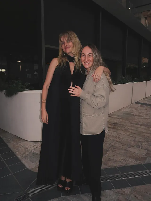 Teresa Palmer standing beside a companion in a black dress.