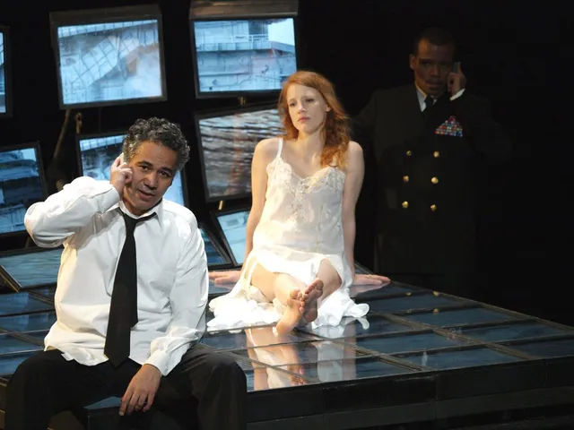 Jessica Chastain sitting barefoot beside a man in a stage scene.