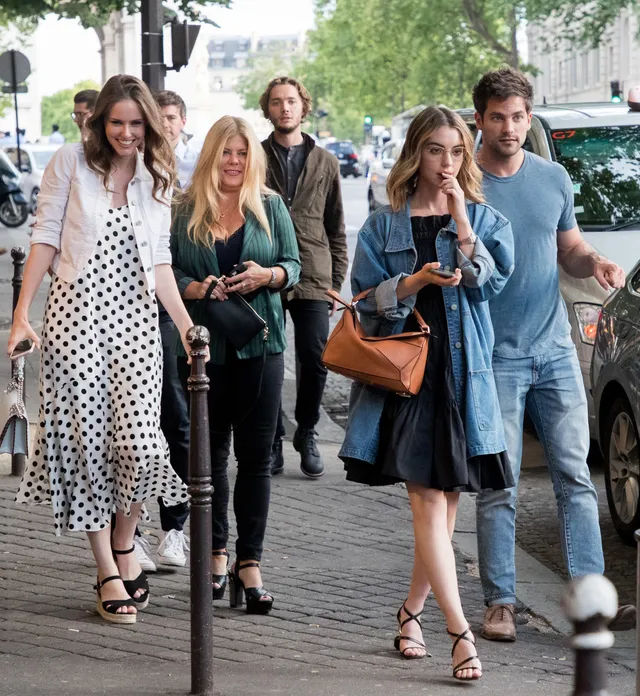Adelaide Kane walking with companions in a blue dress.