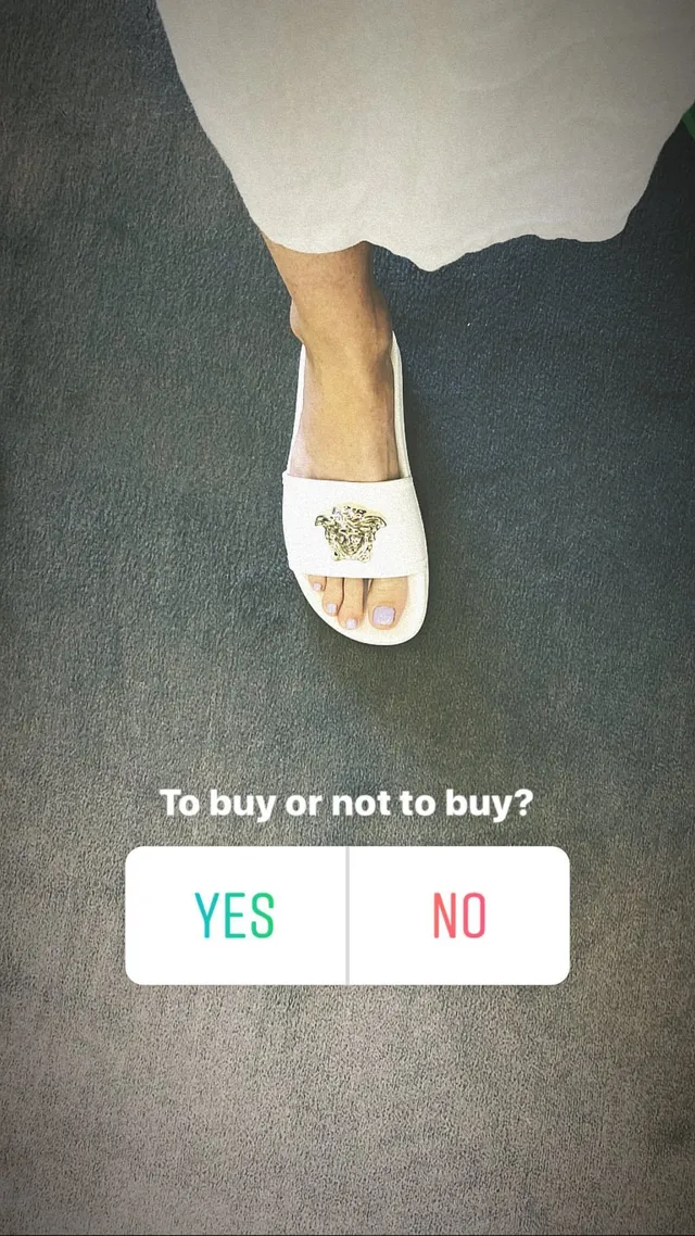 Alice Eve wearing white flat slides indoors.