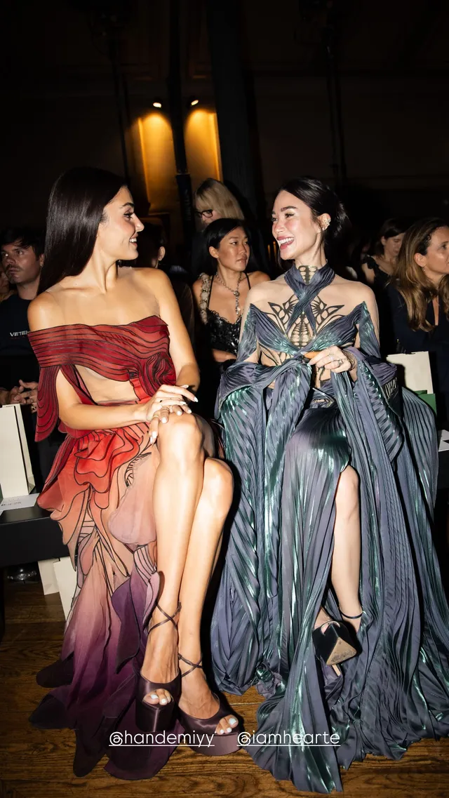 Hande Erçel sitting in a red dress and purple platform heels.