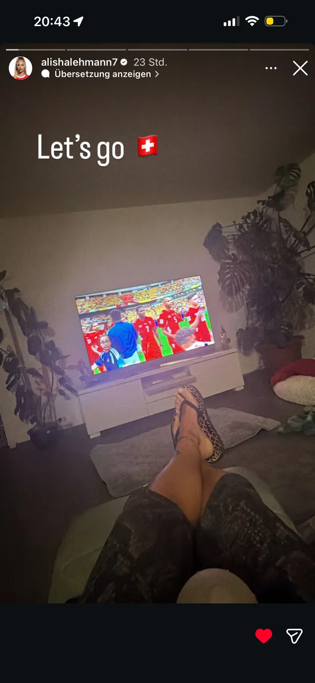 Alisha Lehmann resting her bare feet in front of a television.