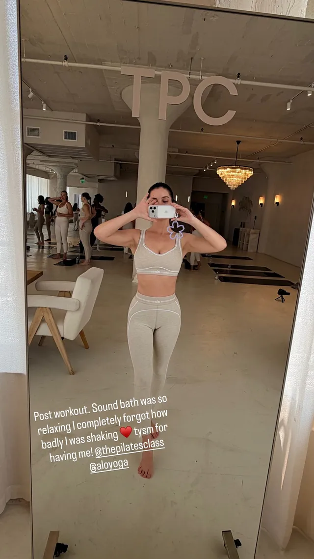 Adelaide Kane taking a mirror portrait in workout clothes.