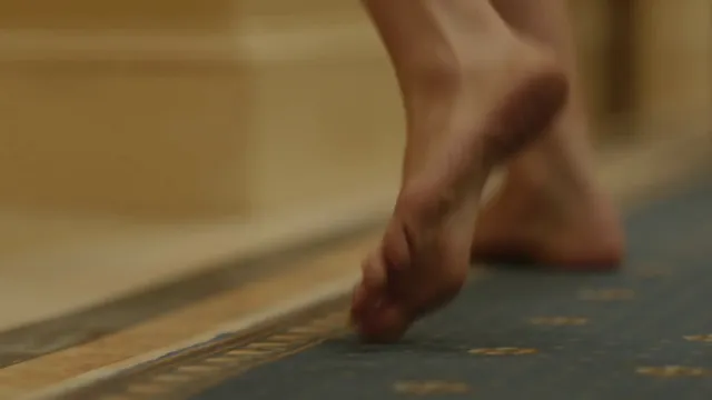 Olivia Wilde raising a bare heel in a film scene.