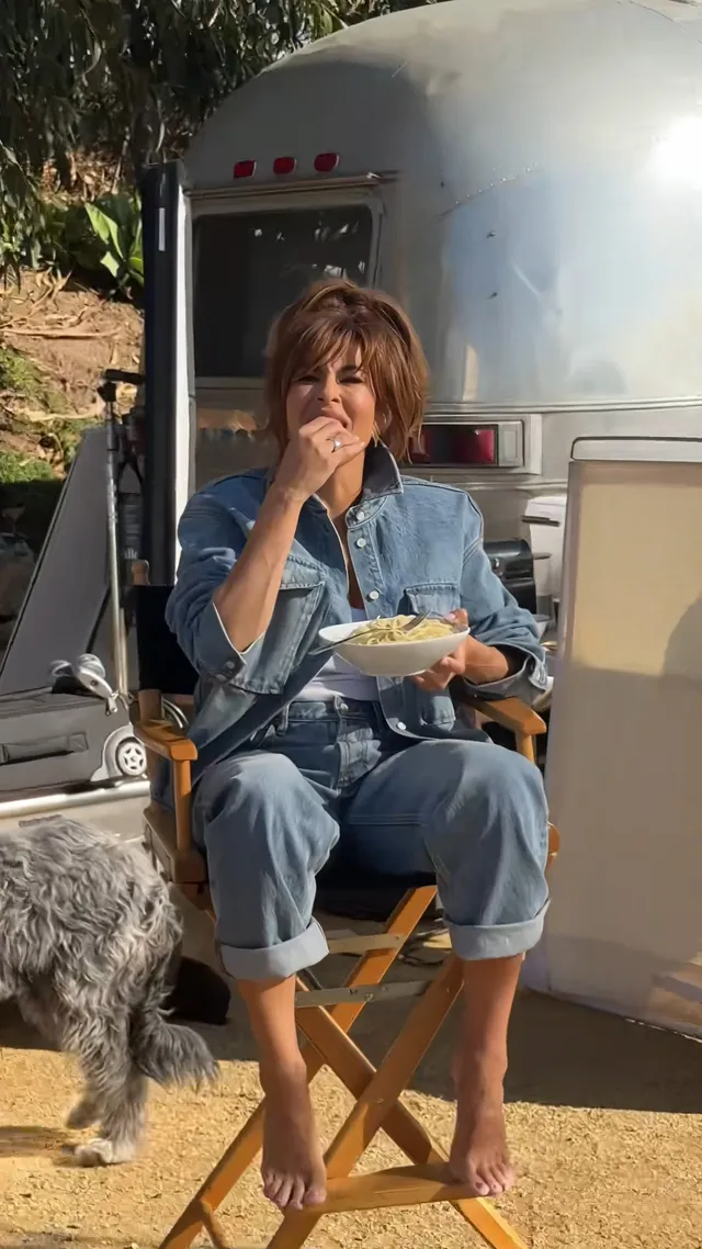 Eva Mendes sitting outside a trailer in a folding chair.