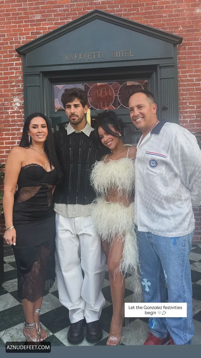 Cierra Ramirez in a white feathered dress with family outside a building.