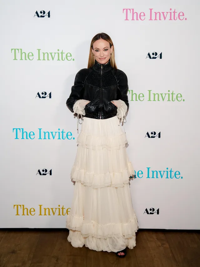 Olivia Wilde posing at an event in a long tiered skirt.