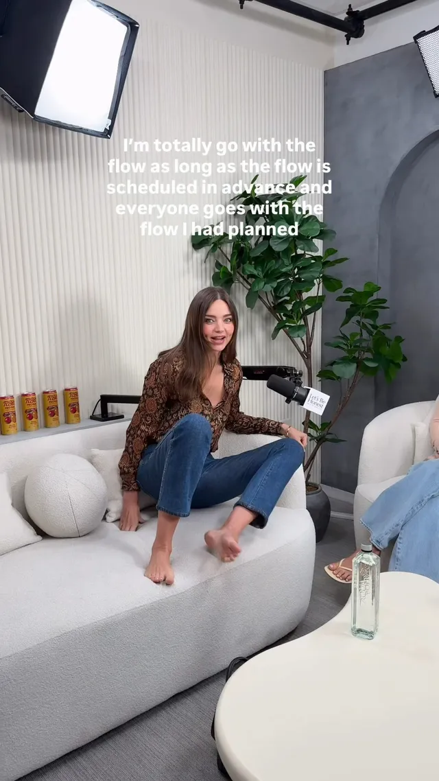 Miranda Kerr a relaxed barefoot pose on a white sofa.