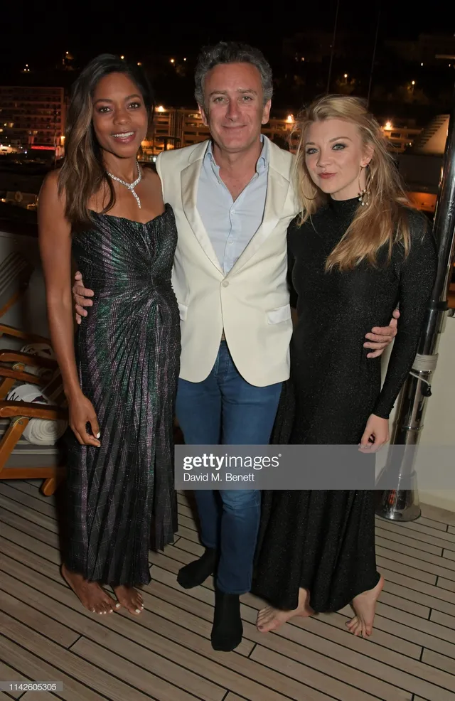 Natalie Dormer posing with guests in a long black outfit.