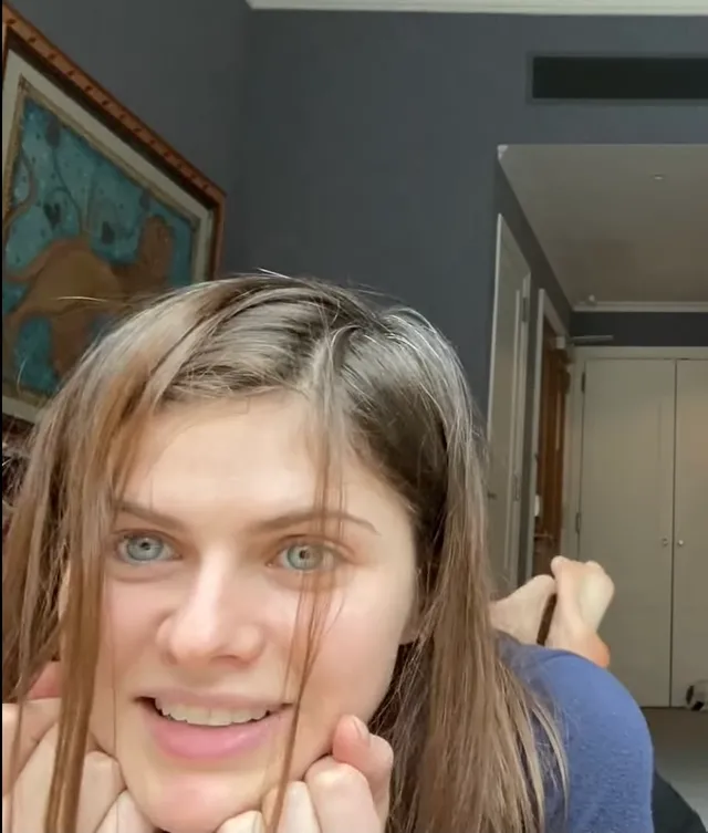 Alexandra Daddario lying indoors with bare feet behind her.
