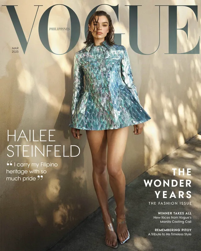 Hailee Steinfeld posing barefoot for a magazine cover in a blue dress.