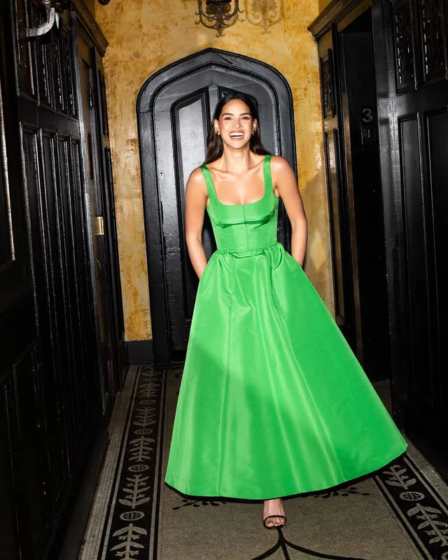 Adria Arjona wearing a green gown and black heeled sandals.