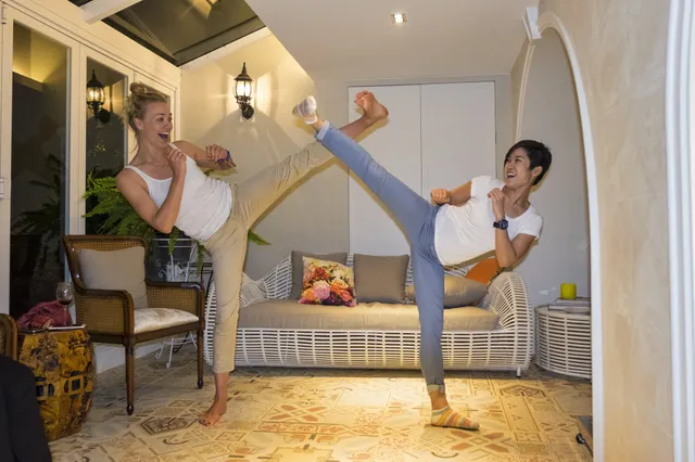 Yvonne Strahovski posing with a companion in a living room.