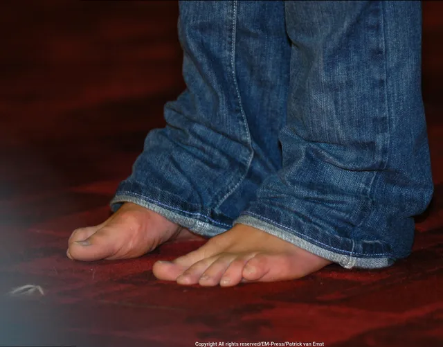 Keira Knightley a close detail of bare feet beneath jeans.