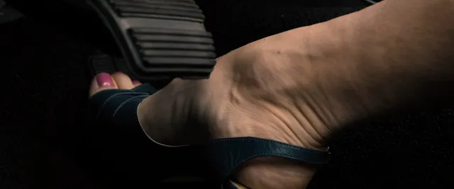 Scarlett Johansson: close view of a foot resting in a dark open-toe shoe.