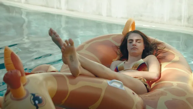 Cara Delevingne relaxing on an inflatable ring in a pool.