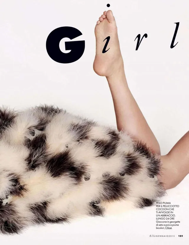 Kate Upton reclining in a patterned coat with a bare sole raised in an editorial crop.