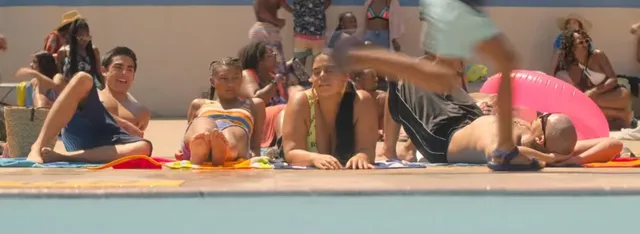 Sierra Capri sitting with friends on a pool deck in a screen capture.