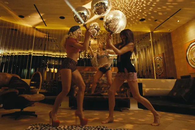 Margaret Qualley a screen scene dancing in a mirrored room.