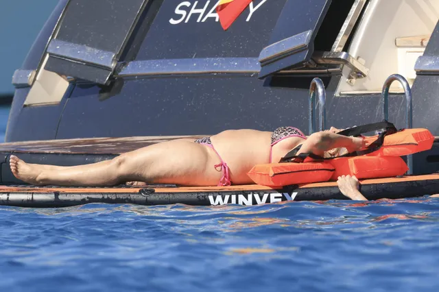 Bebe Rexha sunbathing barefoot on a paddleboard.
