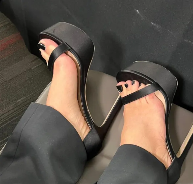 Sarah Michelle Gellar wearing black platform heels beneath dark trousers.