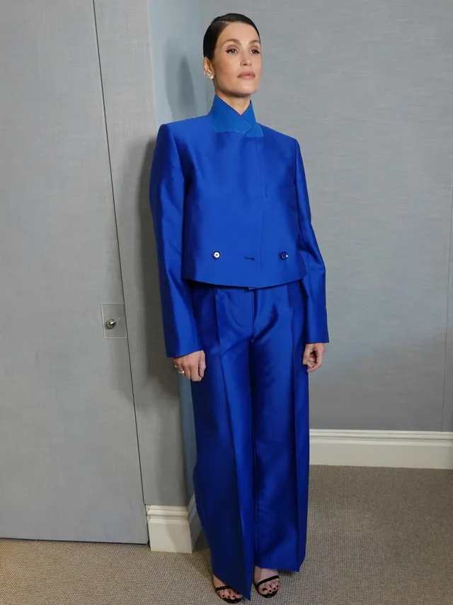 Gemma Arterton standing in a blue trouser suit.