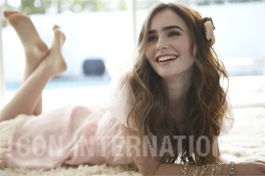 Lily Collins reclining with a bare sole raised behind her.