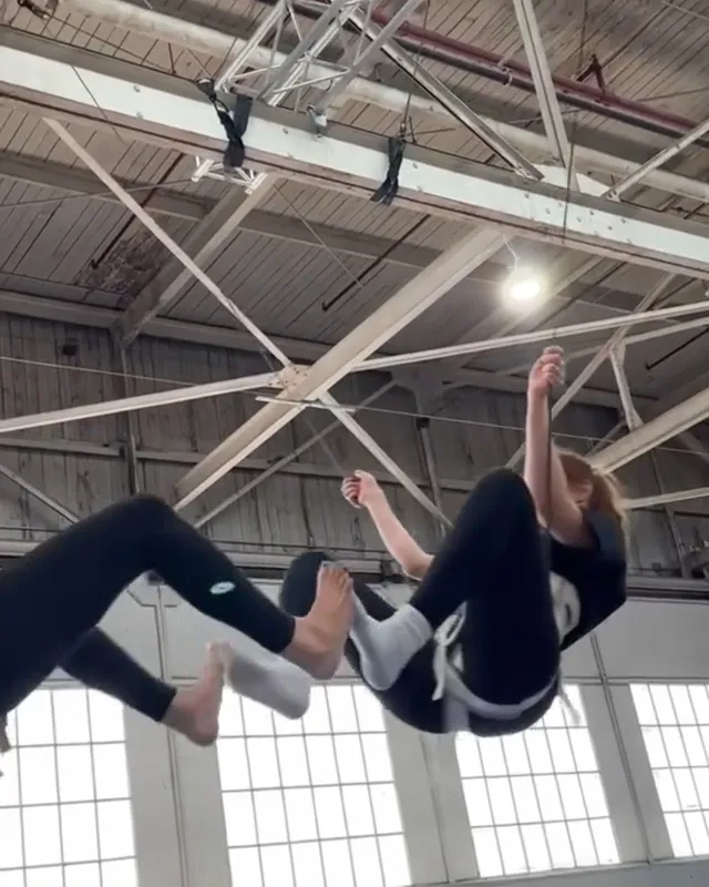 Dafne Keen practicing an aerial exercise in pale socks.