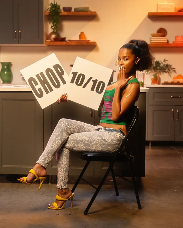 Tyla sitting in yellow heels and patterned trousers during a studio appearance.