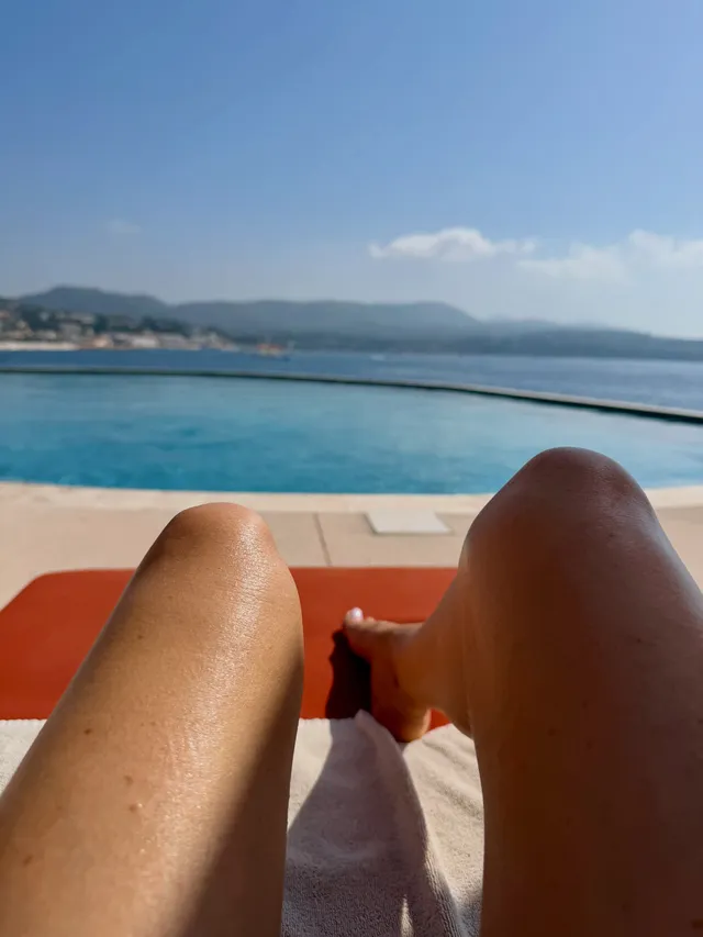 Sarah Michelle Gellar reclining on a boat beside the water with bare legs visible.