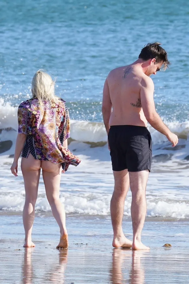 Ariel Winter walking with a companion at the shoreline.