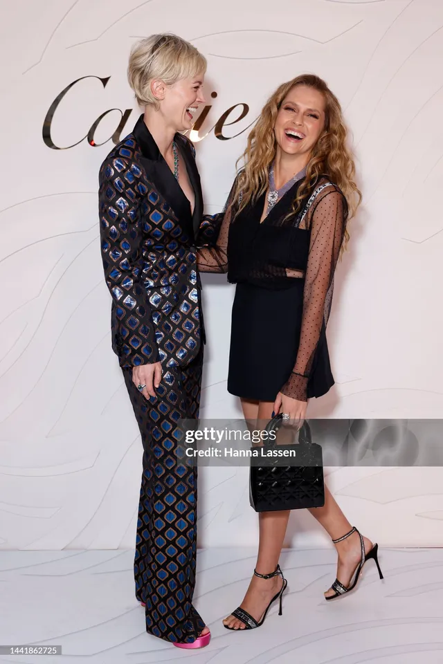 Teresa Palmer standing beside a companion in a black dress.
