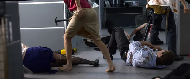 Samara Weaving walking barefoot past two people on a floor in a film scene.