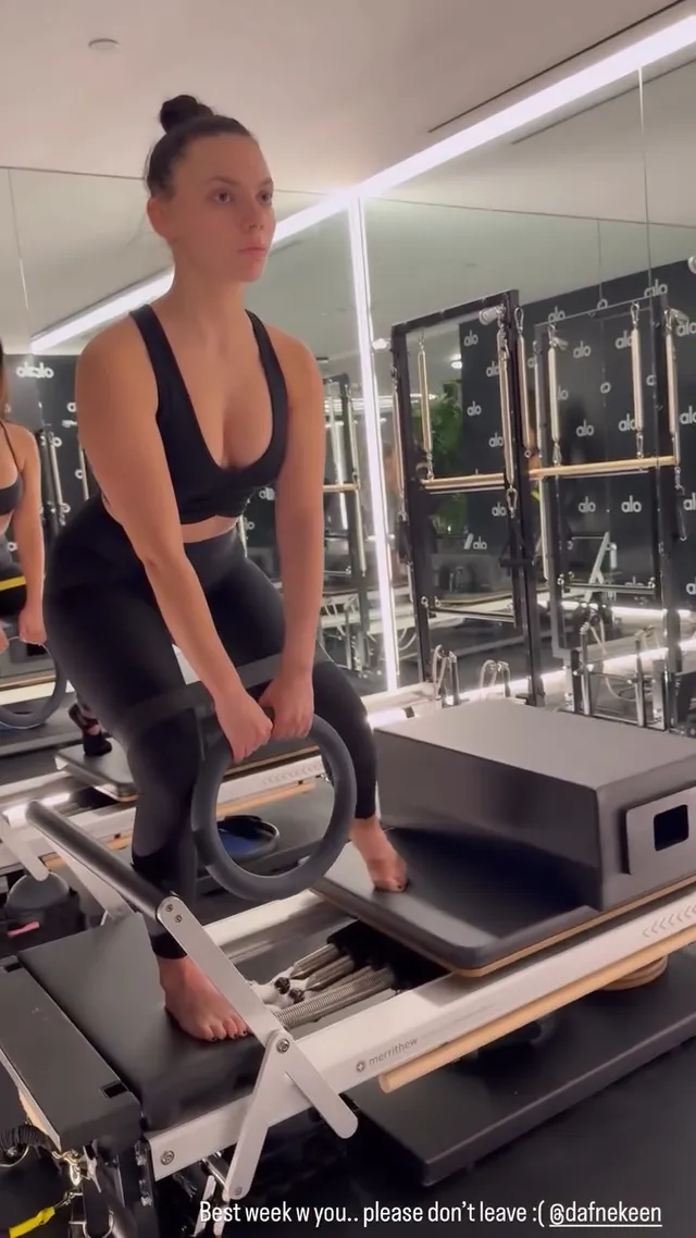 Dafne Keen standing barefoot on a Pilates reformer.