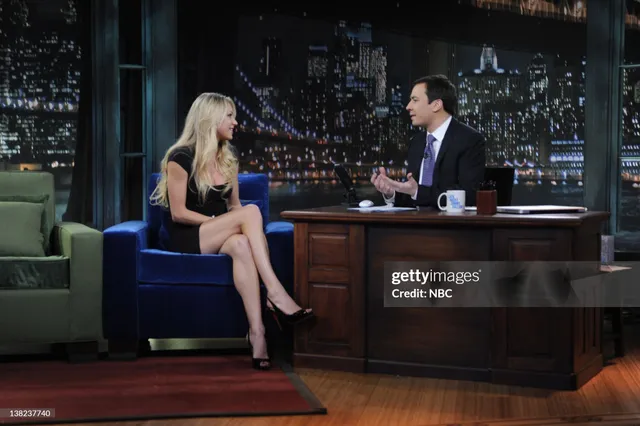 Anna Kournikova sitting in black heels beside a television host.