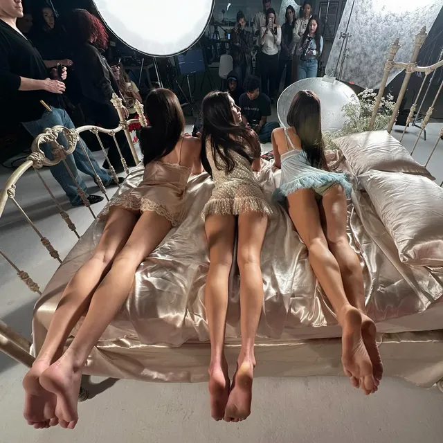 Bella Hadid reclining with guests with bare soles raised backstage.