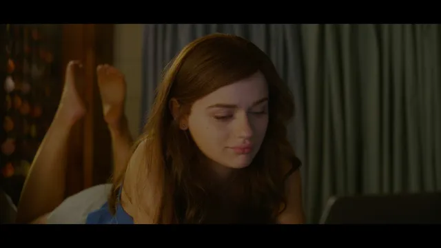 Joey King lying in a film scene with her bare feet raised behind her.