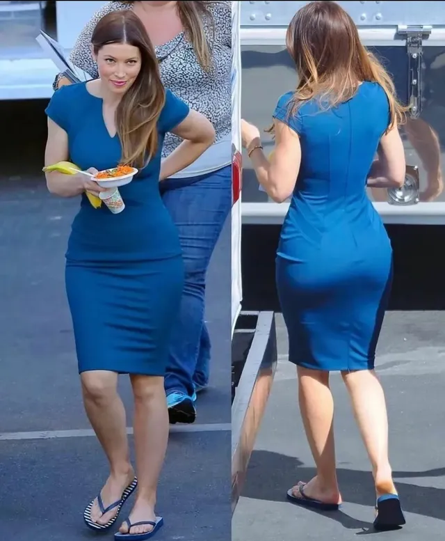 Jessica Biel walking outdoors in a blue dress beside heels.